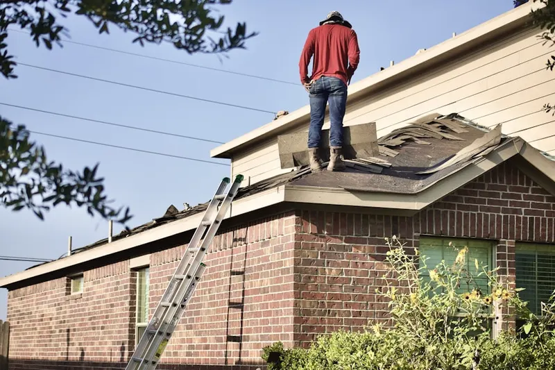 Professional roofer working on a residential roof in Varnum
